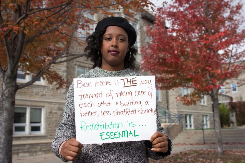 A person holding a sign is standing facing the camera.