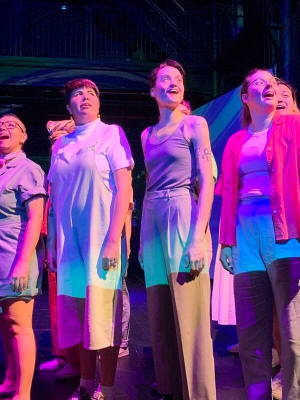 Image of group of people singing in a choir on stage.