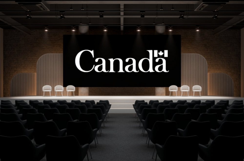 The "Canada" logo appears on a projection screen, with an empty stage of seats and an audience of chairs