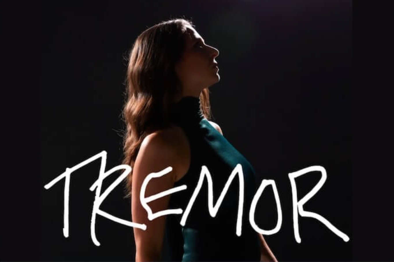 Brianna stands in profile wearing a green dress. "TREMOR" is written across the photo in white.