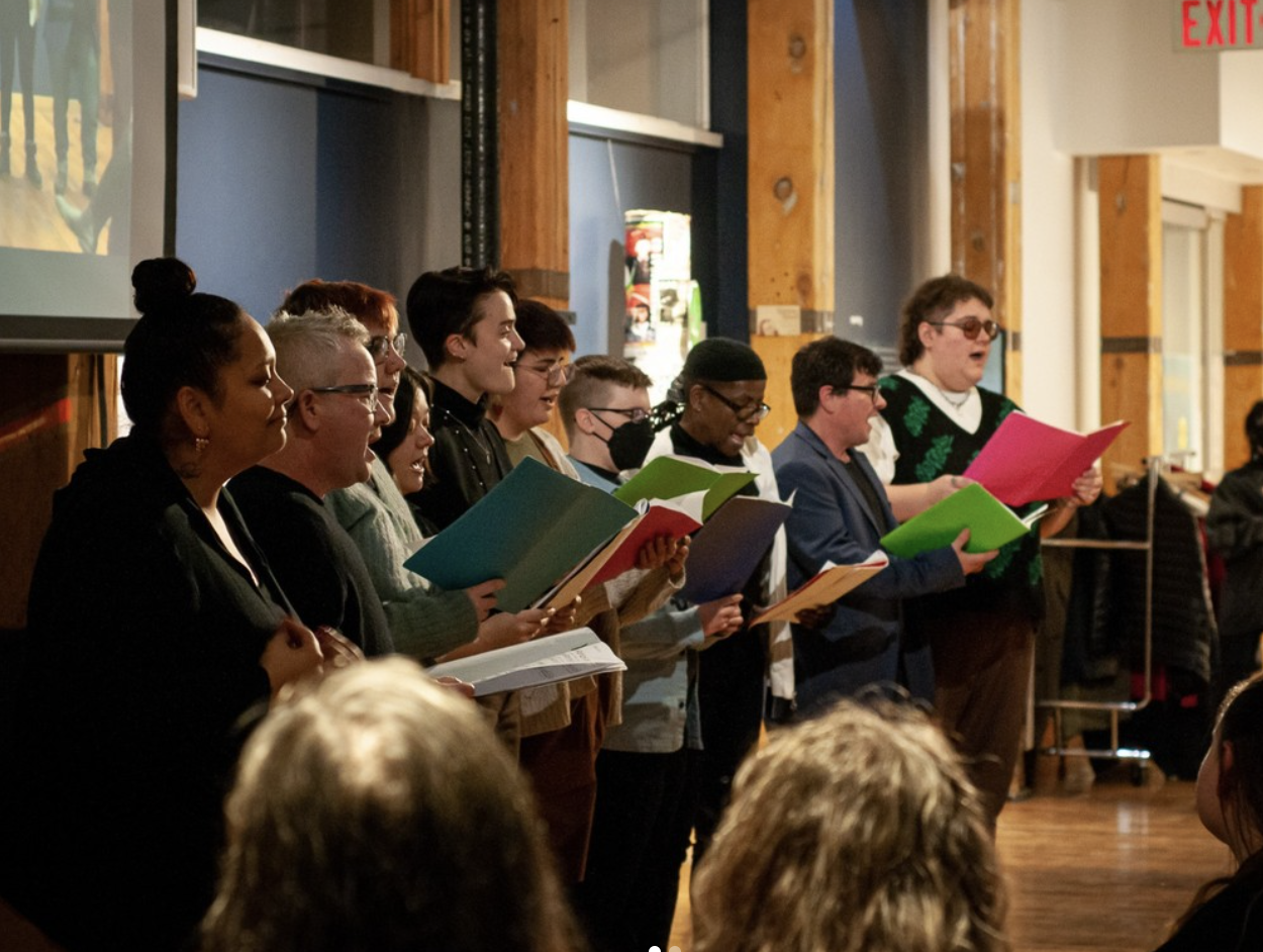 A choir singing and an interpreter signing the songs.