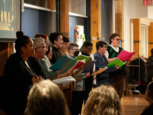 A choir singing and an interpreter signing the songs.